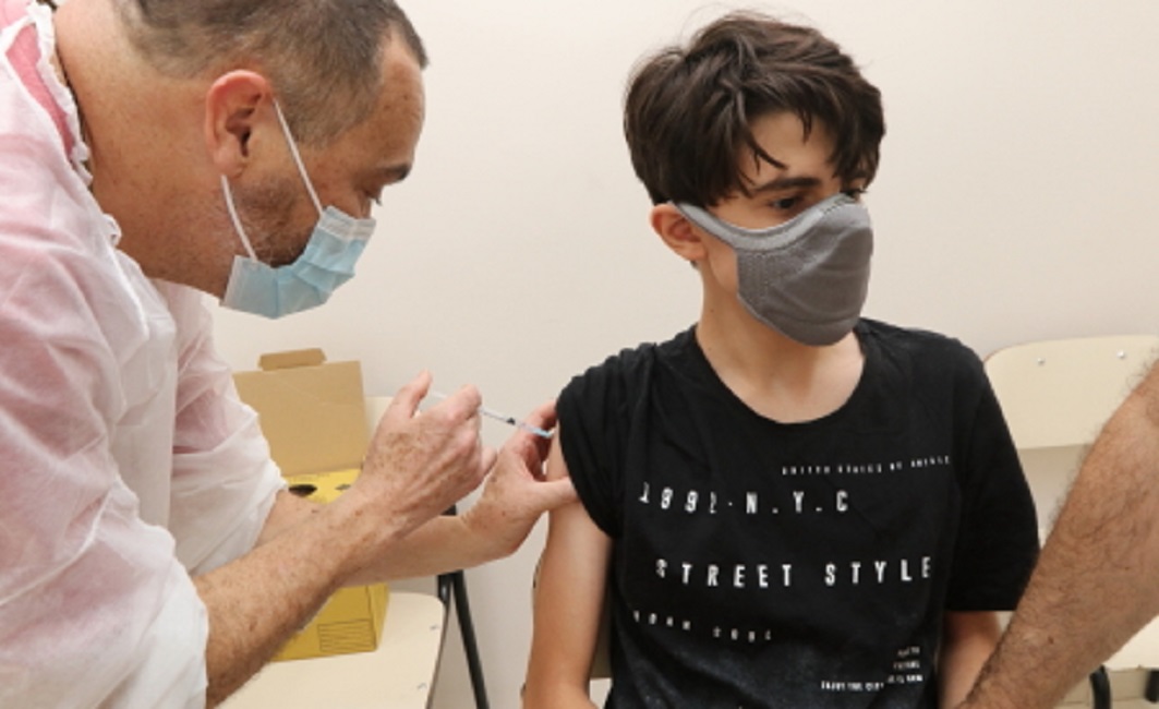 Enfermeiro de Jacareí aplicando vacina contra a covid em adolescente