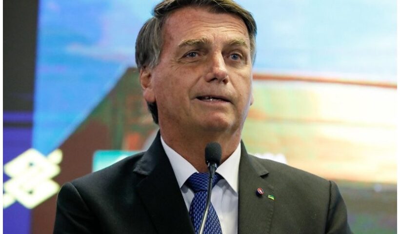 Bolsonaro passa a fazer parte de inquerito sobre ataques aos tres poderes; ex-presidente veste terno escuro e sorri de leve enquanto fala ao microfone