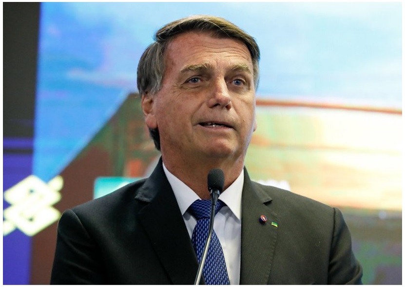 Bolsonaro passa a fazer parte de inquerito sobre ataques aos tres poderes; ex-presidente veste terno escuro e sorri de leve enquanto fala ao microfone