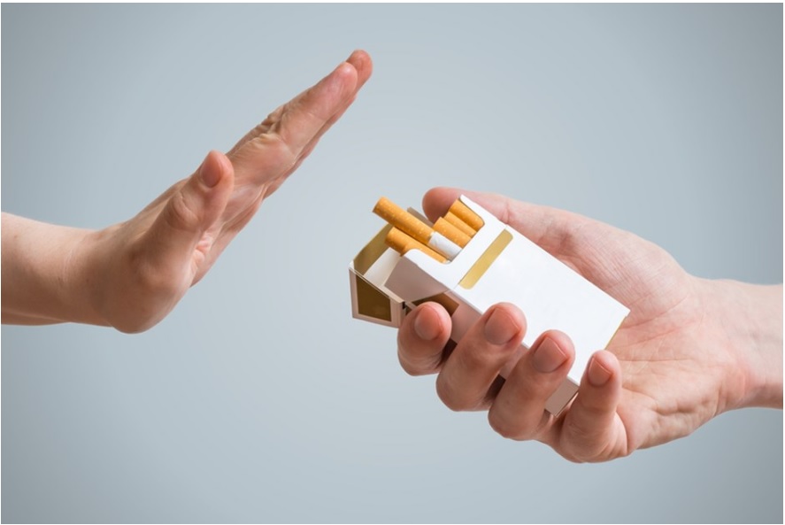 Mão de uma pessoa oferece cigarro para outra que rejeita a oferta