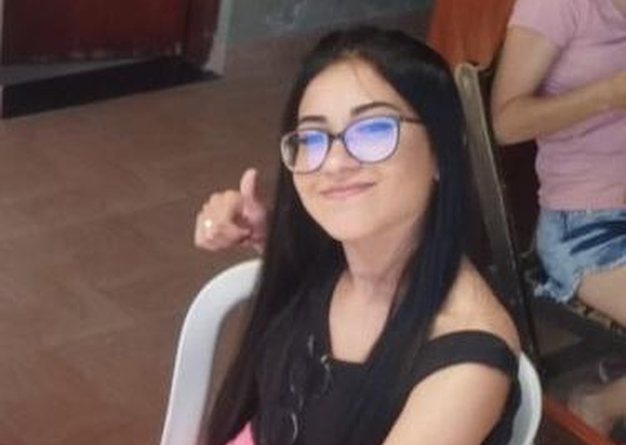 jovem aparece sorrindo com óculos