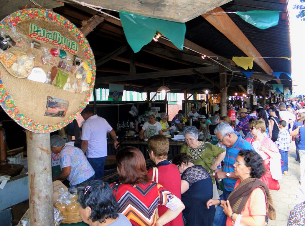 Turistas comprando comida típicas em barracas na festa de aniversário de Paraibuna