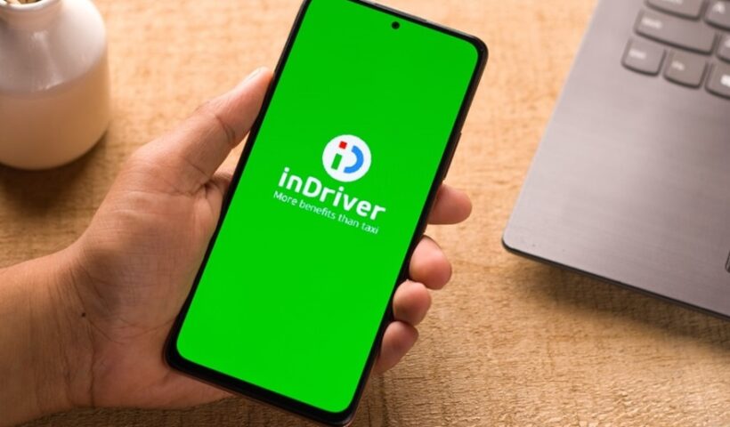 Mão segurando celular mostrando aplicativo InDriver