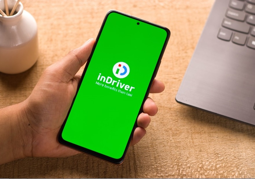 Mão segurando celular mostrando aplicativo InDriver