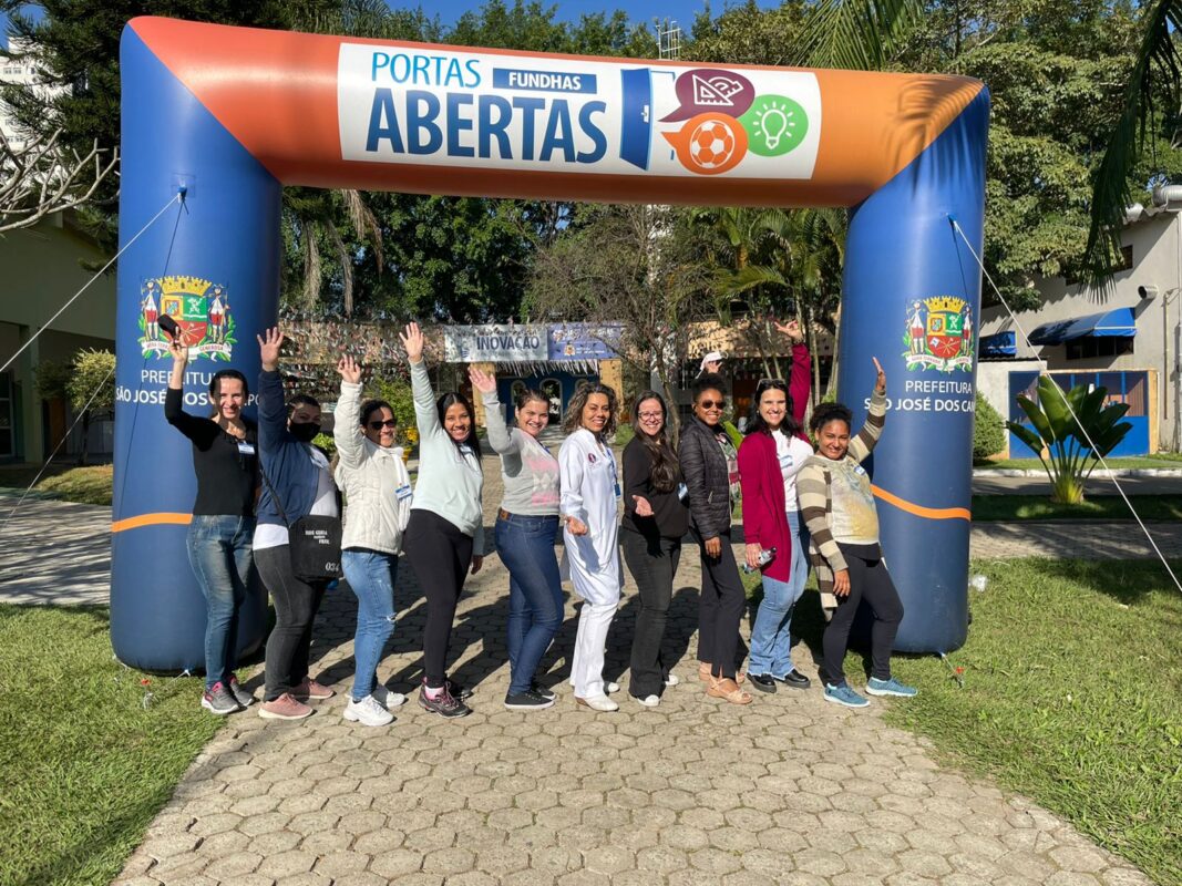 Alunas do Programa portas abertas de SJC posam em frente de inflável com logo da prefeitura. Programa inicia aulas aos sábados