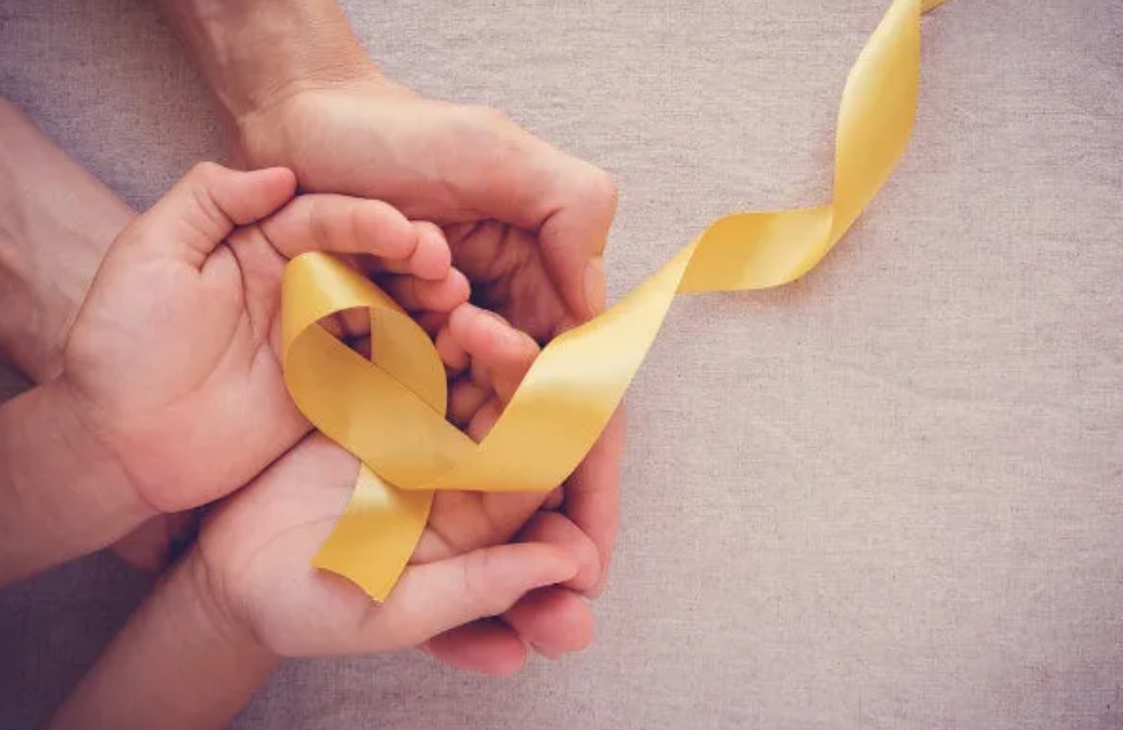 Mãos de pai e filho segurando uma fita amarela em alusão ao Setembro Amarelo. CVV de São José divulgou ações na rádio CBN Vale