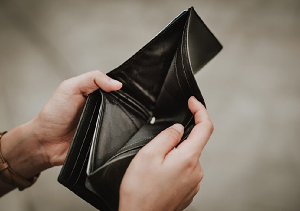 Mãos segurando carteira vazia, para ilustrar que salário mínimo ideal deveria ser acima de 6 mil reais em agosto, segundo o Dieese