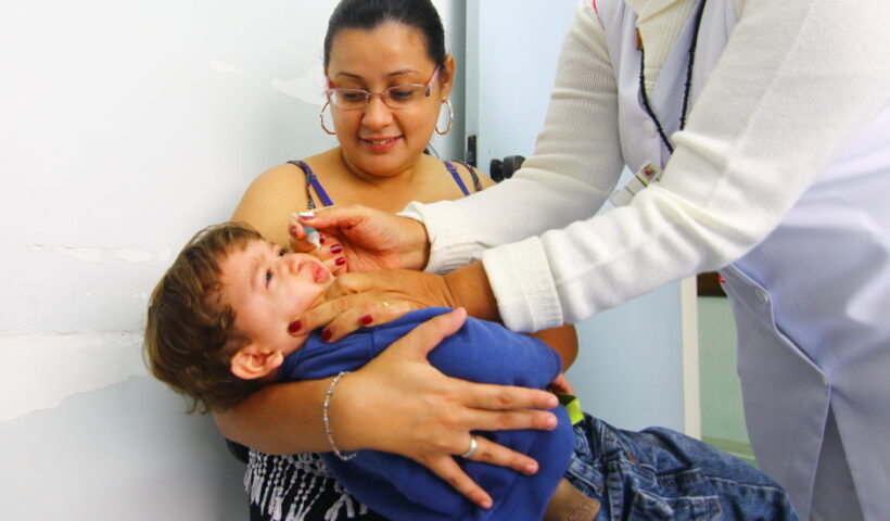 Criança no colo de sua mãe para tomar gotinha contra a Polio. São José realiza vacinação contra Pólio, covid e Influenza