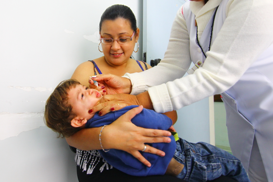 Criança no colo de sua mãe para tomar gotinha contra a Polio. São José realiza vacinação contra Pólio, covid e Influenza