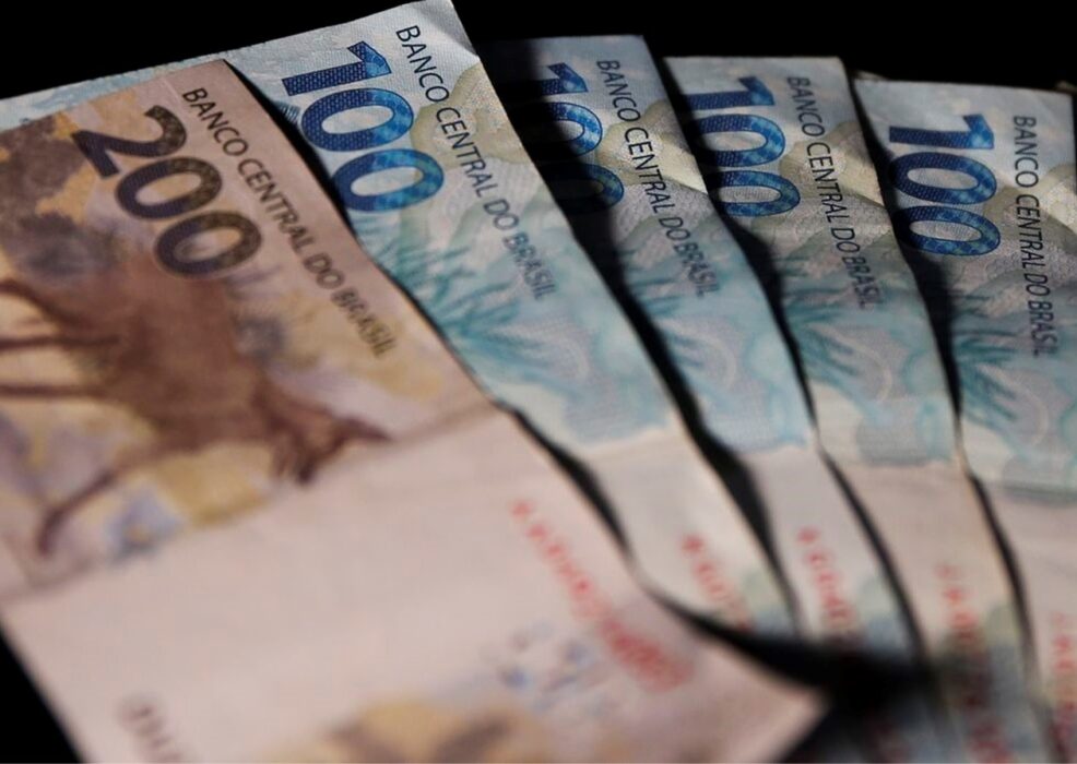 notas de 100 e 10 reais em cima da mesa; salário mínimo de R$1.320 passa a valer em 1º de janeiro de 2023