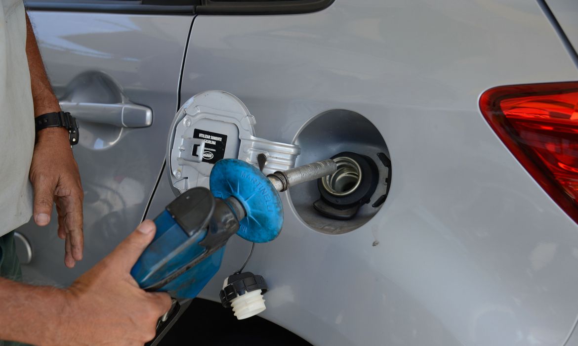 Foto de tanque bomba de combustível abastecendo tanque de carro. Petrobras anunciou redução no litro da gasolina a partir de 2 de setembro de 2022