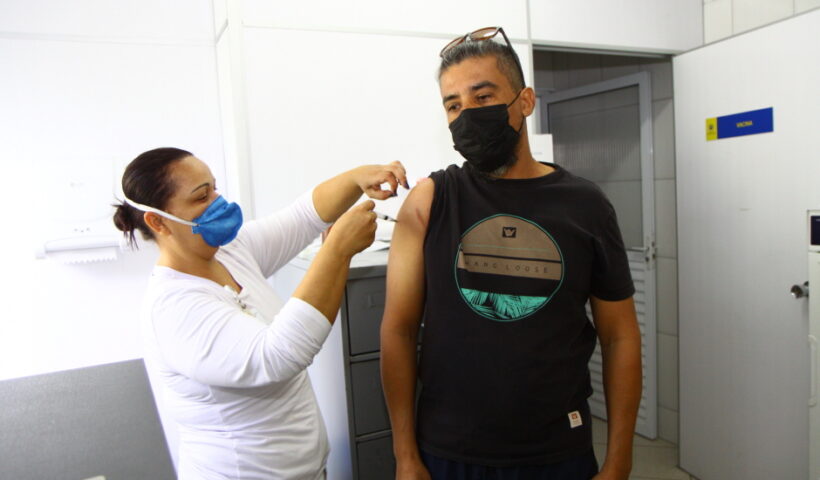 Homem sendo vacinado contra covid por enfermeira. São José fará vacinação contra covid e influenza em empresas