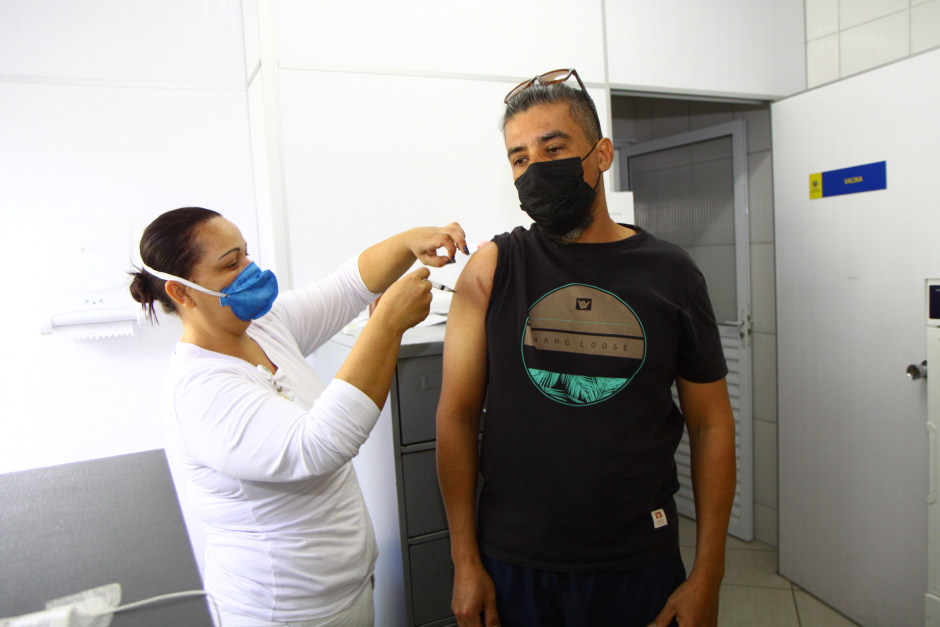 Homem sendo vacinado contra covid por enfermeira. São José fará vacinação contra covid e influenza em empresas