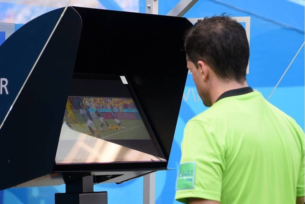 árbitro de futebol em frente à tela de var. Política decidida no Var?