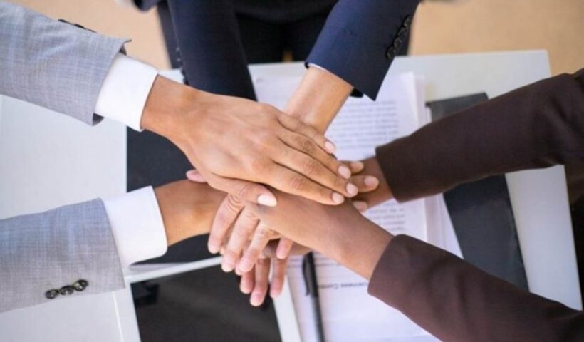 mãos unidas aocentro deuma mesa para enfatizar Relacionamento no mercado de trabalho