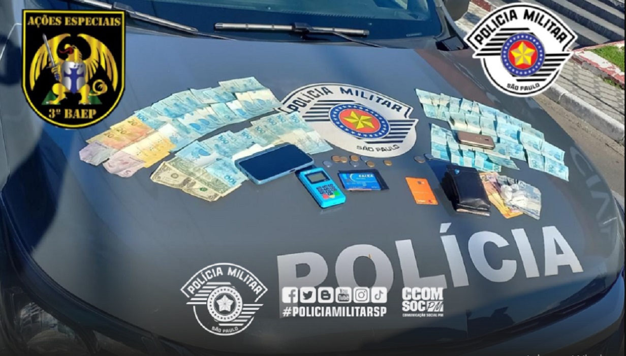 Dinheiro, cartões e máquina de cartões, no capô de veículo da PM. Suepeito foi preso por corrupção ativa