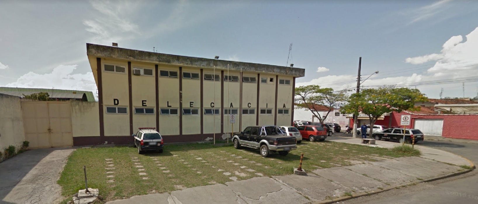 fachada da delegacia de lorena, pintada de amarelo claro, com carros estacionados em frente ilustram texto sobre adolescente alvo de tentativa de homicídio