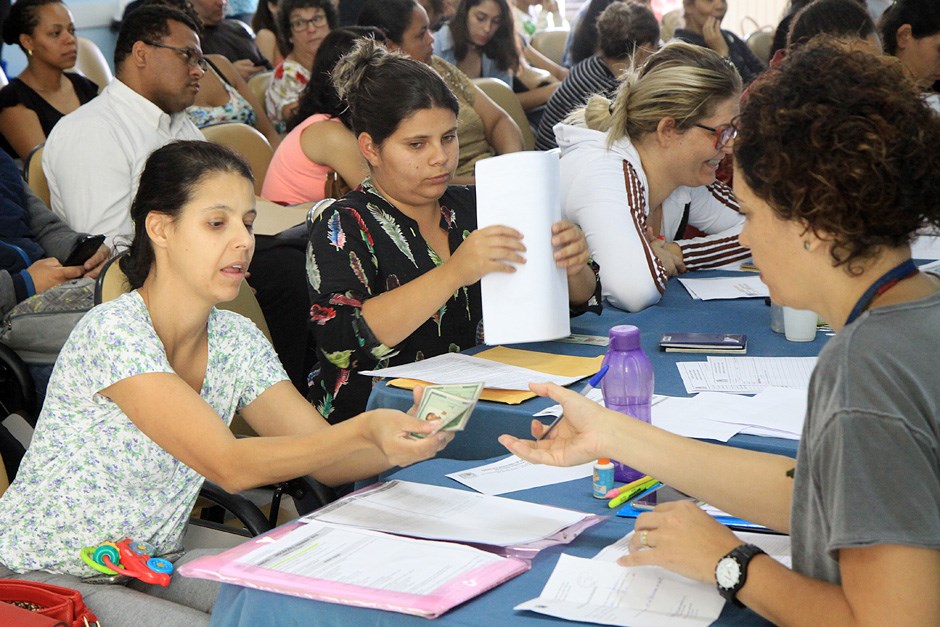 Profissionais de educação recebendo inscrições de bolsas de estudo em SJC