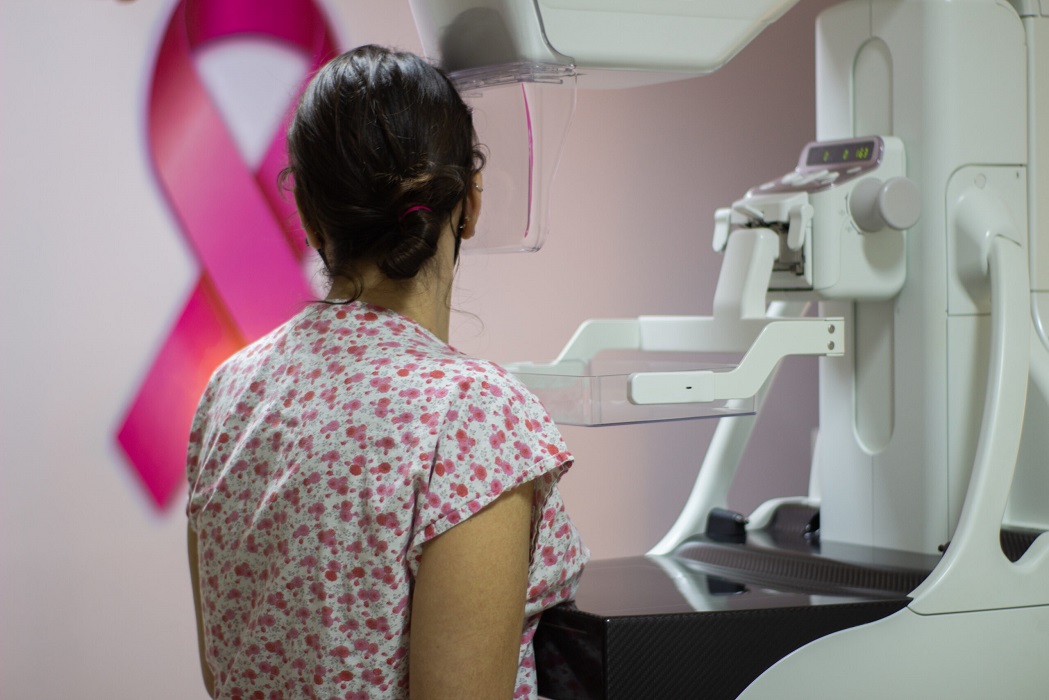 Mulher de costas para fazer mamografia. Outubro Rosa: Jacareí promove mutirão de exames neste sábado (15)