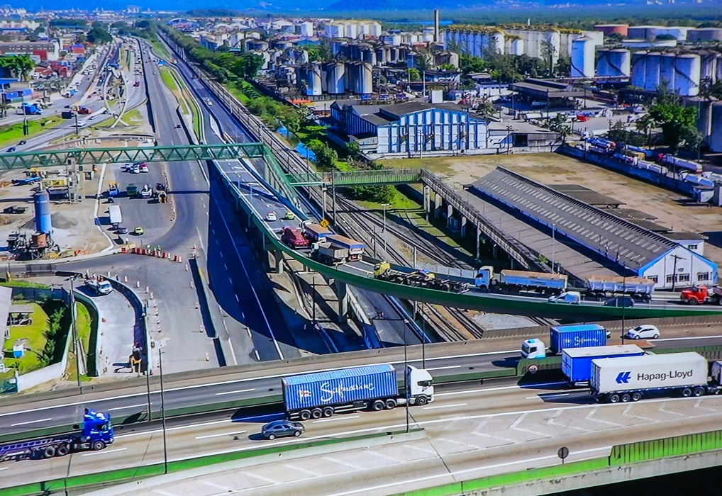 complexo viário da entrada de santos visto de cima, com carros prédios e caminhões