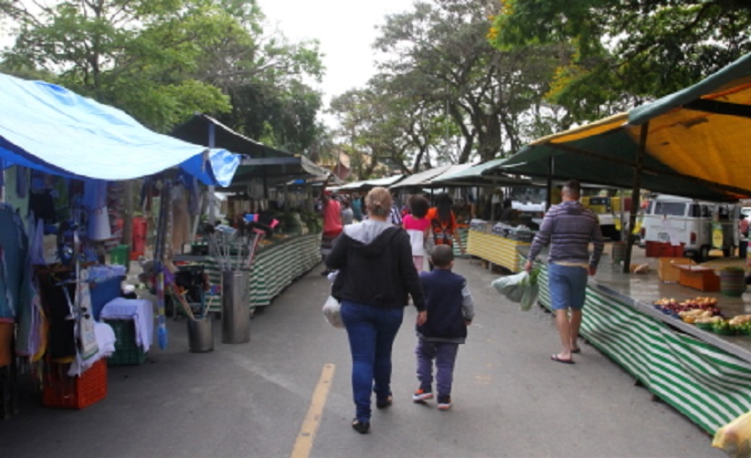 feira livre em jacarei, com consumidores caminhando na rua e bancas dos dos lados da via ilustram texto sobre o que abre e fecha no ano novo