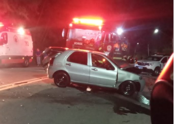 carro prateado envolvido em acidente em que homem fica preso às ferragens é retirado com guincho; ao fundo, caminhão do corpo de bombeiros