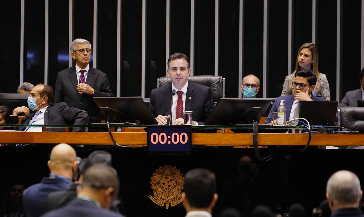 presidente da camara dos deputados sentado à mesa do congresso, com outros dois parlamentares ao fundo. congresso aprova regras para orcamento secreto