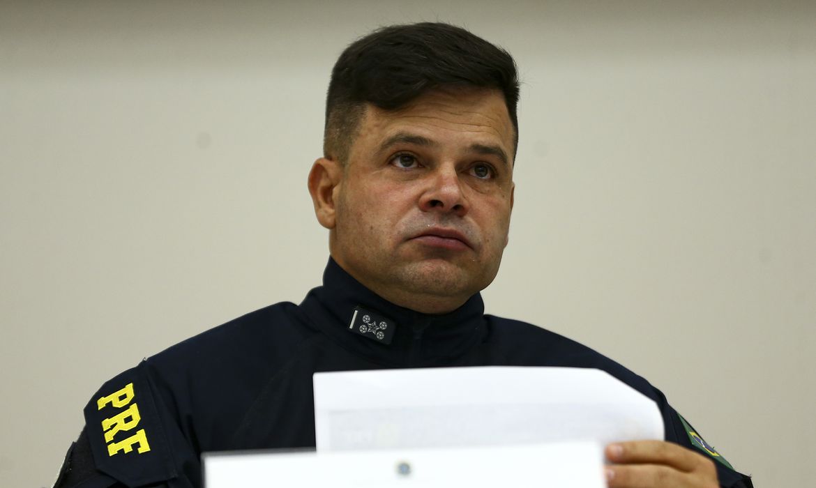 diretor-geral da PRF, Silvinei Vasques, segura uma folha de papel e veste uniforme preto