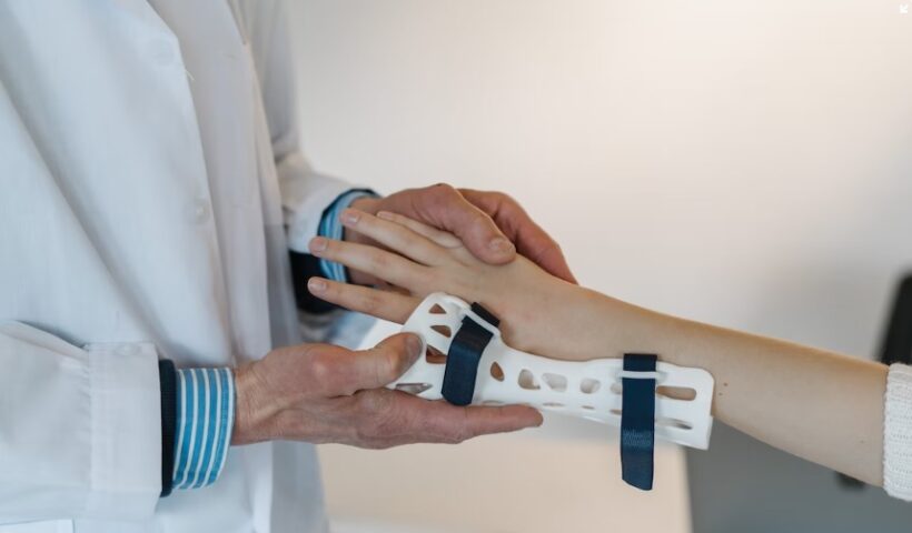 inovações tecnológicas - médico segura mão de paciente enquanto coloca órtese branca fabricada por impressora 3D