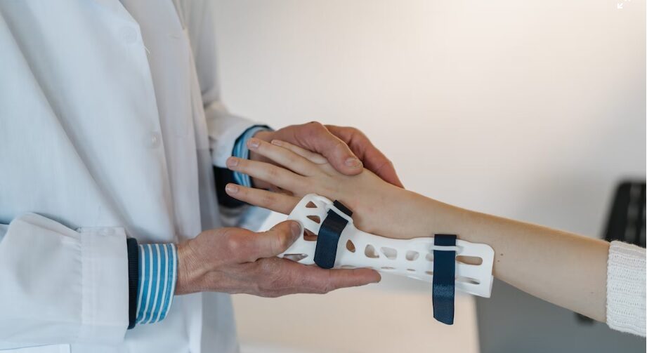 inovações tecnológicas - médico segura mão de paciente enquanto coloca órtese branca fabricada por impressora 3D