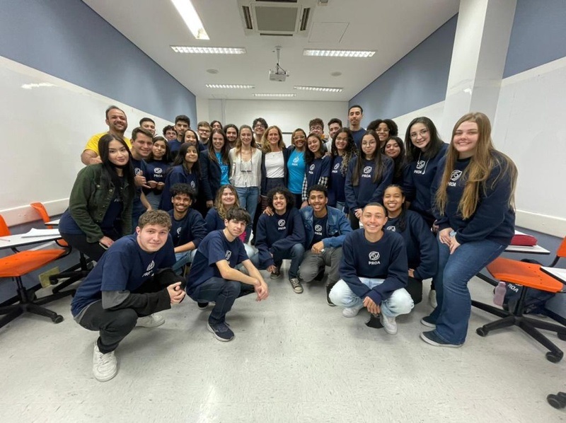 dezenas de alunos do instituto proa com uniforme azul marinho, sorrindo para a câmera. curso profissionalizante grátis