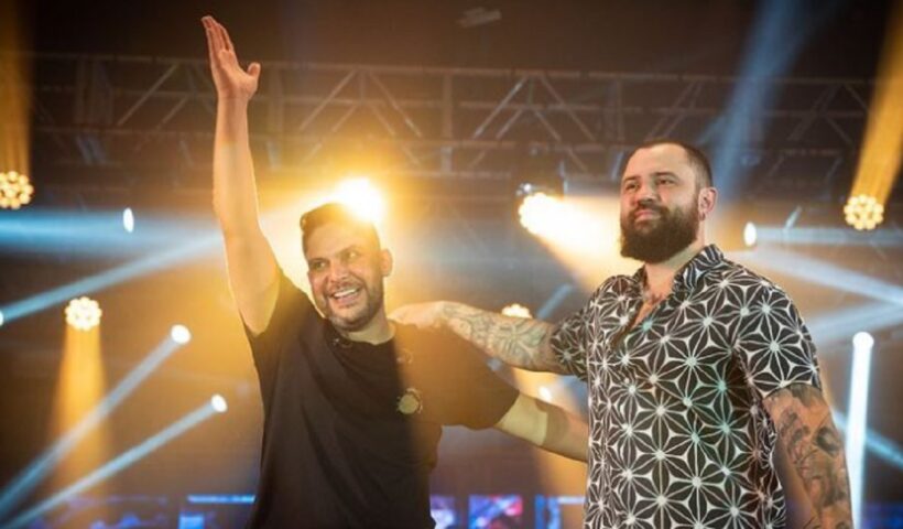 jorge e mateus estao sobre o palco, vestem camisa preta e estampada. eles se apresentam no vale