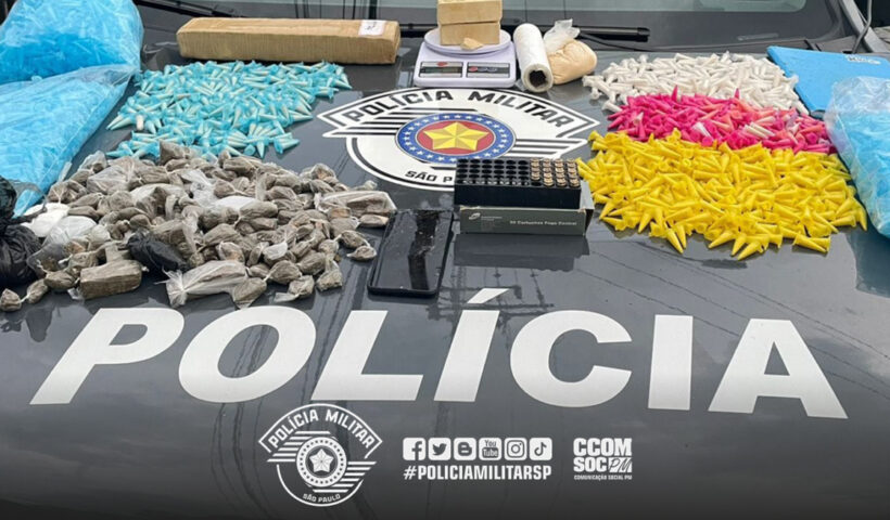 polícia apreende adolescente com drogas em Lorena. Imagem de pinos coloridos de cocaína, munições e maconha sobre capô da viatura policial