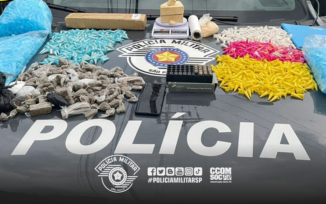 polícia apreende adolescente com drogas em Lorena. Imagem de pinos coloridos de cocaína, munições e maconha sobre capô da viatura policial