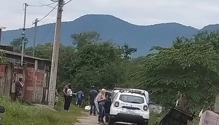 pessoas e um carro branco estão no local onde um pescador de 70 anos morreu atingido por raio em caraguatatuba