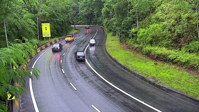 quatro carros de passeio trafegam pela tamoios, com pista molhada, sentido litoral, no ano novo