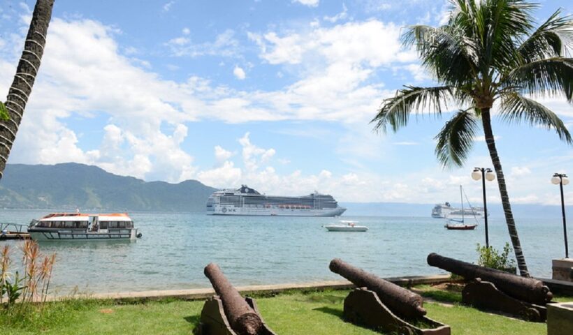 ilhabela, que reivindica total dos royalties do petroleo explorado na regiao, aparece na imagem com mar azul, navios e três canhões no solo, apontados para o mar.