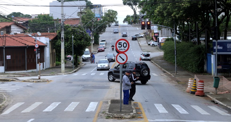 avenida perseu, no jardim satélite, com carros, pedestres e placa de sinalização de velocidade