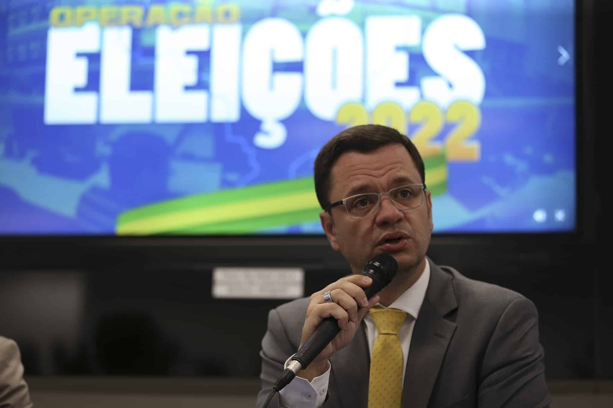 ex-ministro e ex-secretário de Justiça fala ao microfone, veste terno cinza e gravata amarela; terá audiência de custódia hoje