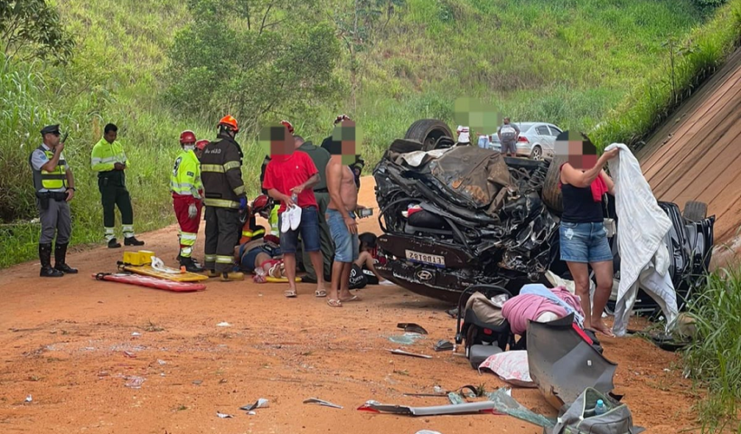 carro capotado e em destroços, há pessoas em volta, morro com gramado verde ao funo; bebe de tres meses está entre feridos