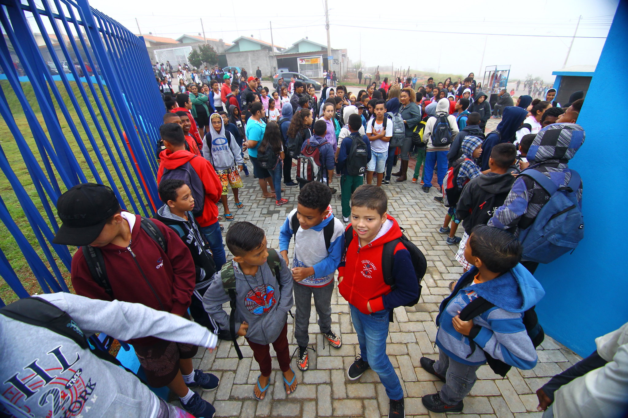 dezenas de crianças com mochila entram pelo portão da escola; projeto prevê enfermaria nas escolas