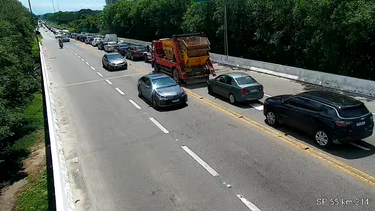 estradas cheias de carros na volta do ano novo nos dois sentidos da sp55; além de carros de passeio, há caminhões