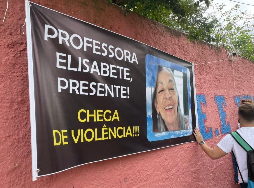 cartaz com foto de professora morta em escola de São Paulo. Governo abre canal para receber denúncias de ataques em escolas