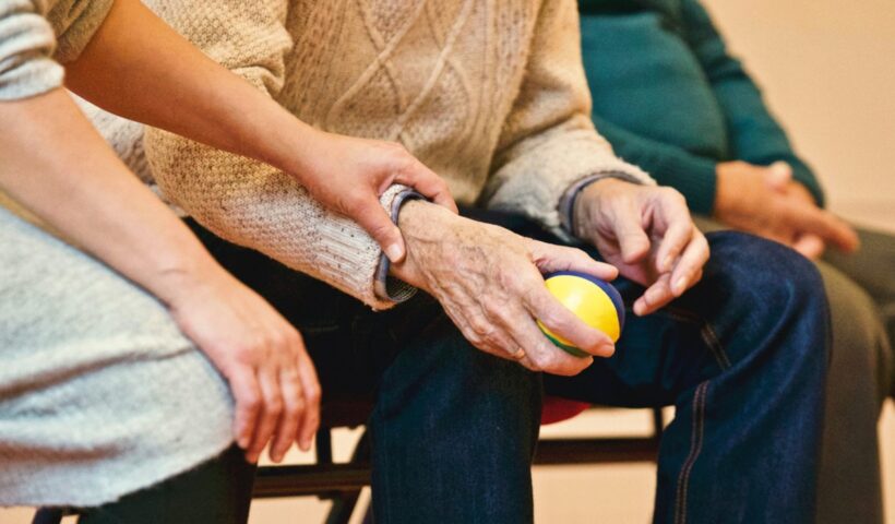Pessoa Idosa sendo amparada pelas mãos de uma senhora