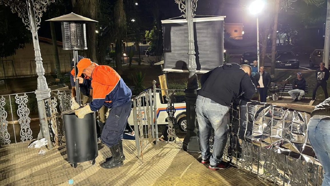 Funcionários da prefeitura de Taubaté instalando aquecedores para moradores em situação de rua