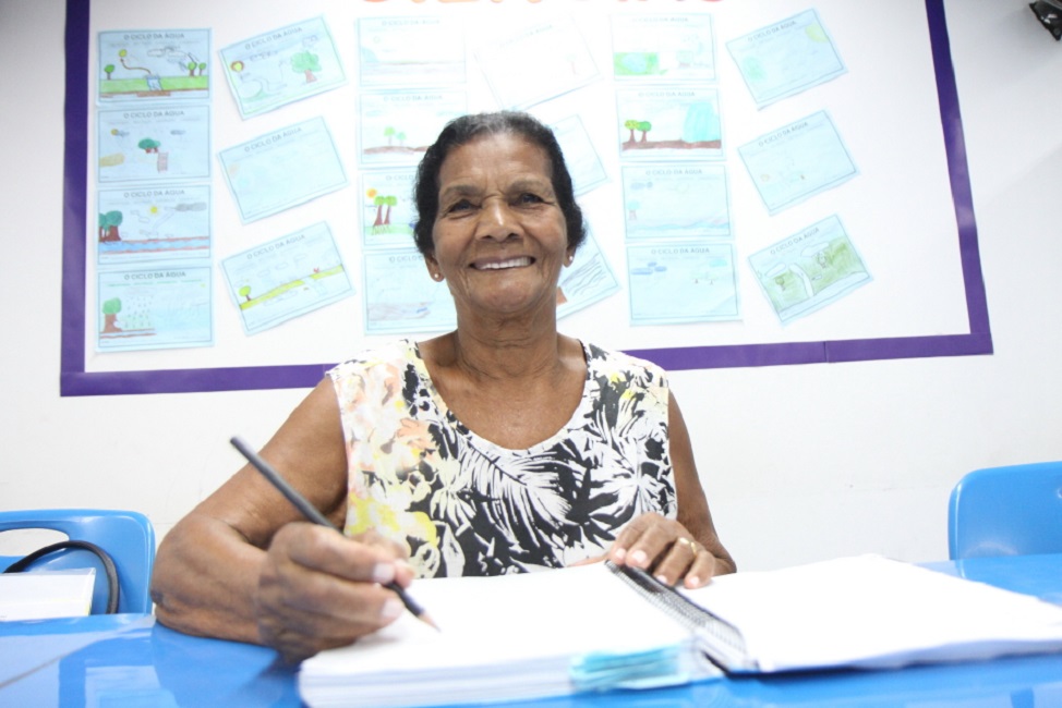 Mulher madura, estudando em unidade do EJA que está com instruções abertas para o segundo semestre