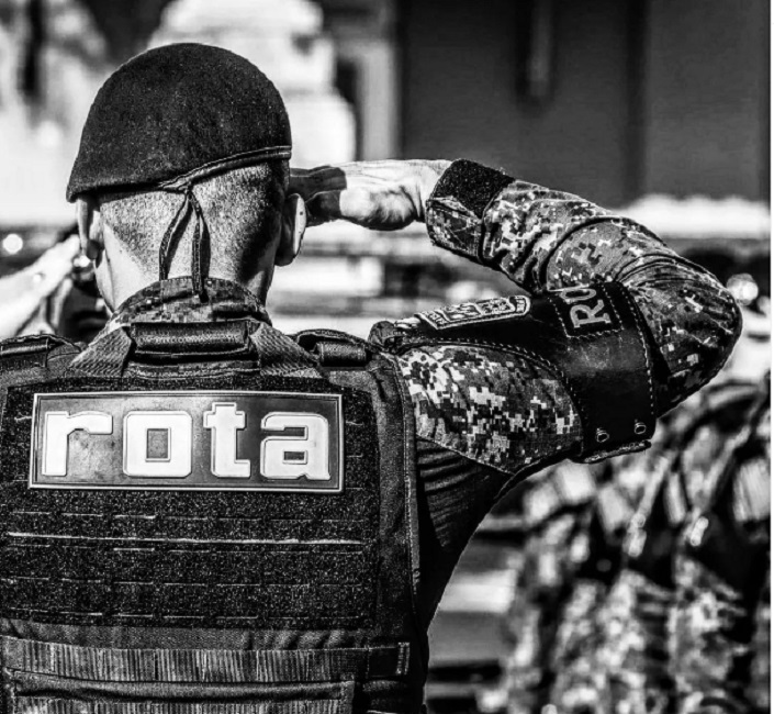 Soldado da Rota, de costas, batendo continência. Polícia Civil conclui inquérito dos suspeitos da morte do soldado da Rota, no Guarujá