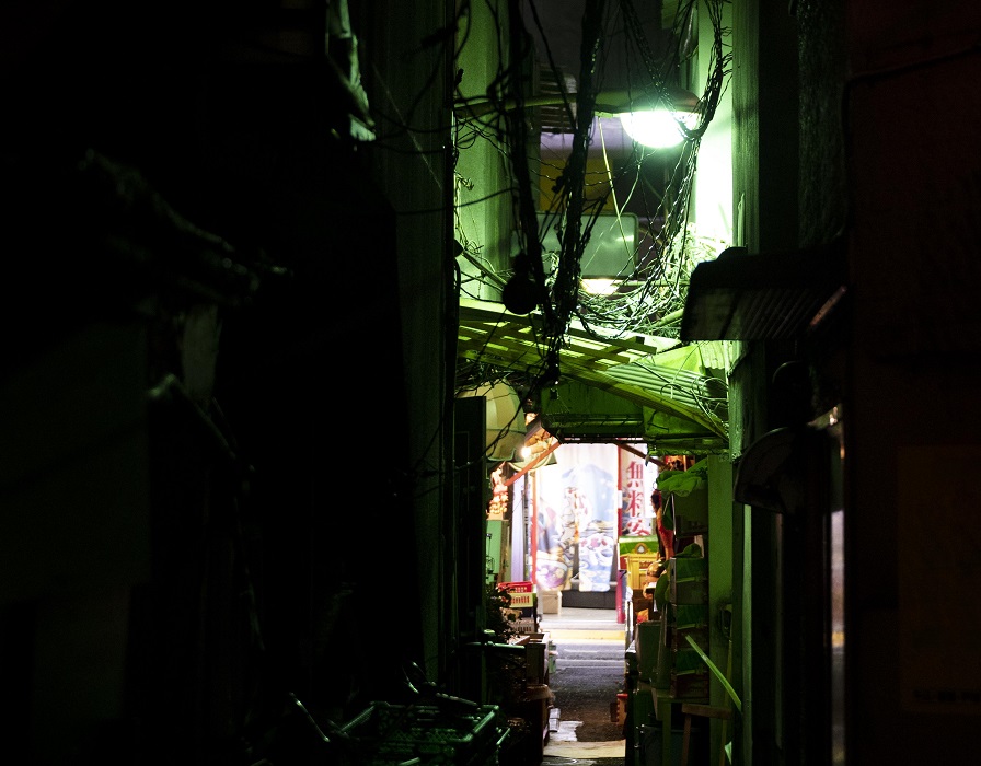 Rua estreita, à noite, mal iluminada, como se fosse em bairro periférico de baixo potencial aquisitivo