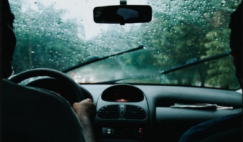 Casal dentro de veículo com parabrisa molhado pela chuva. Serra Antiga da Tamoios é temporariamente interditada por alto volume de chuvas