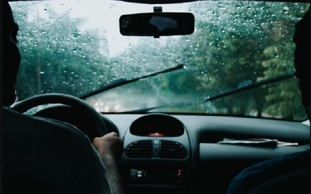 Casal dentro de veículo com parabrisa molhado pela chuva. Serra Antiga da Tamoios é temporariamente interditada por alto volume de chuvas